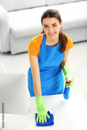 Young woman cleaning workpl...