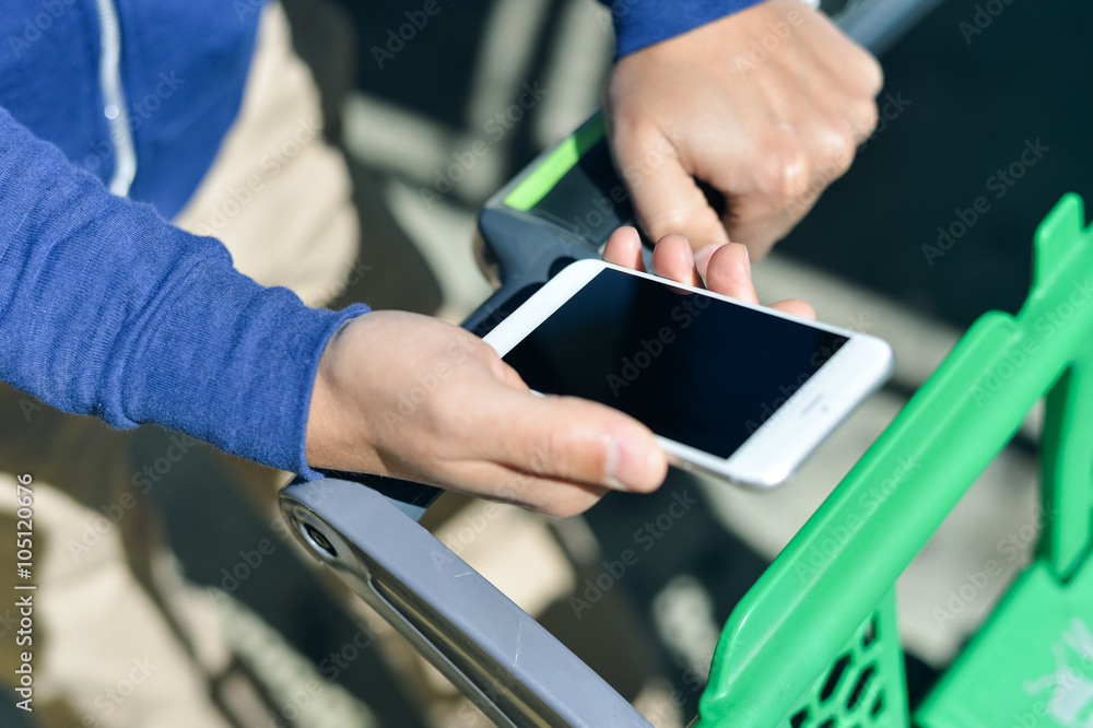 Closeup on person holding mobile smartphone in hand during shopping