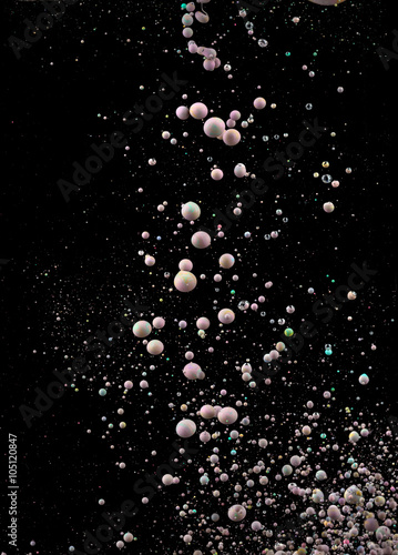Photographs of oil drops creating bubbles. A detailed colorul abstract design isolated on black background. Liquid colors mixing in dynamic flow. 
