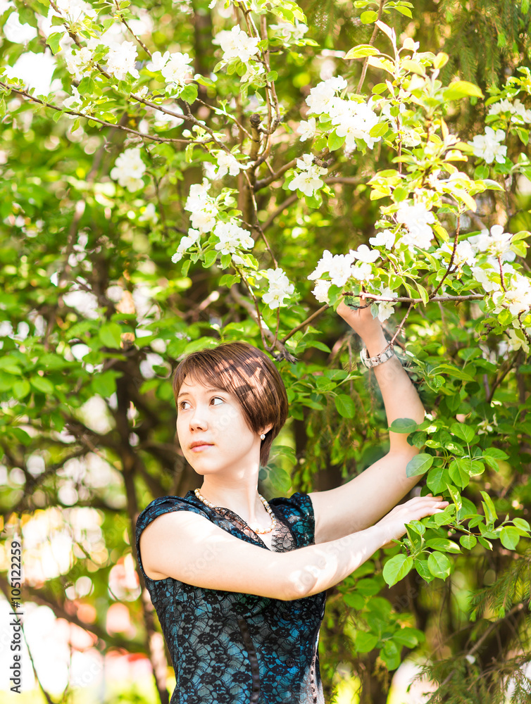 Beautiful young asian woman in flowering spring garden. Beautiful young asian woman in flowering spring garden.