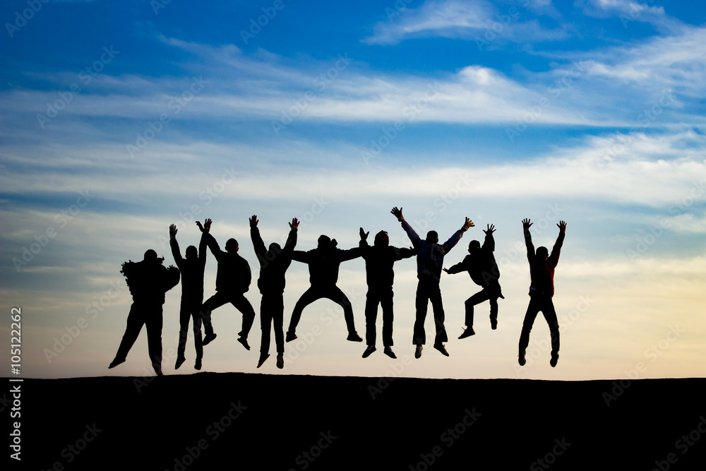 Obraz premium group of young people is jumping on top of the mountain