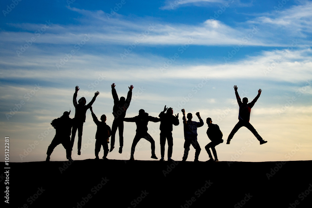 group of young people is jumping on top of the mountain