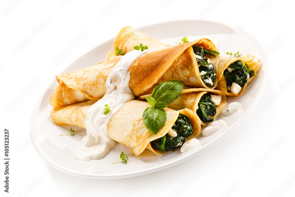 Crepes with spinach and feta cheese on white background 