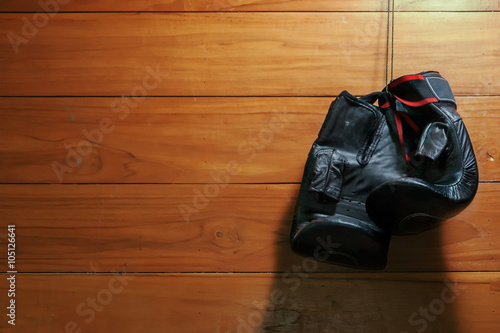 Muay Thai boxing gloves hanging on wooden wall 