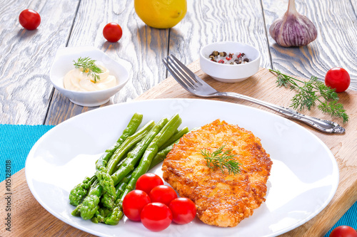 meat chop, asparagus and cherry tomatoes, served with white sauc