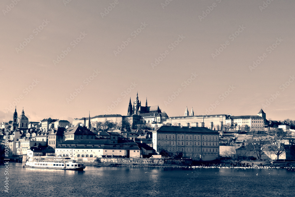Hradcany castle in Prague seen from the river, in black and white. Monochrome image filtered in retro, vintage style with soft focus and red filter; high contrast dramatic effect.