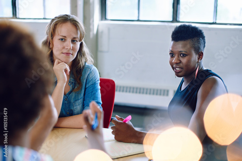 Unposed group of creative business people in an open concept office brainstorming their next project. photo