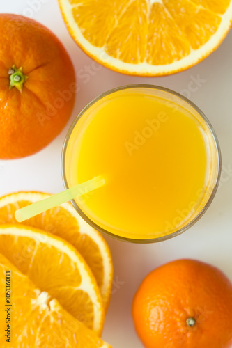 Bright orange juice with slices and havel and fruit of different citrus as tangerine, orange. Selective focus and shooting angle 90 degrees