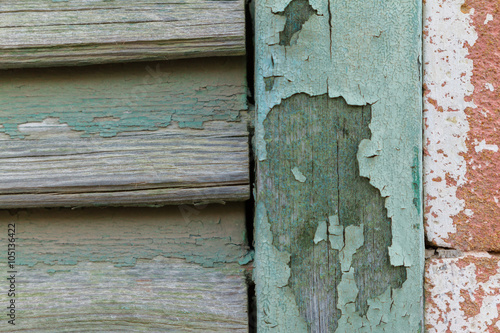 Cyan peeling paint window wood planks and pink brick wall © Iordanis Pallikaras