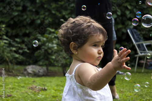 Girl playing with soap bubbles in the garden
