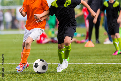 Training and football match between youth soccer teams. Young boys playing soccer game. 