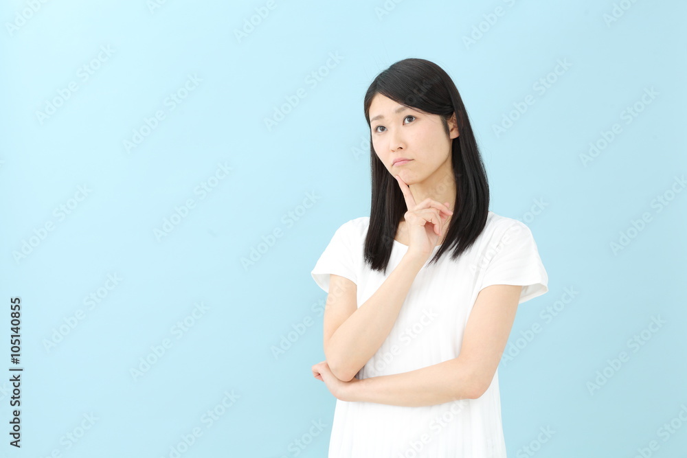 考える若い女性・ブルーバック 考える若い女性・ブルーバック