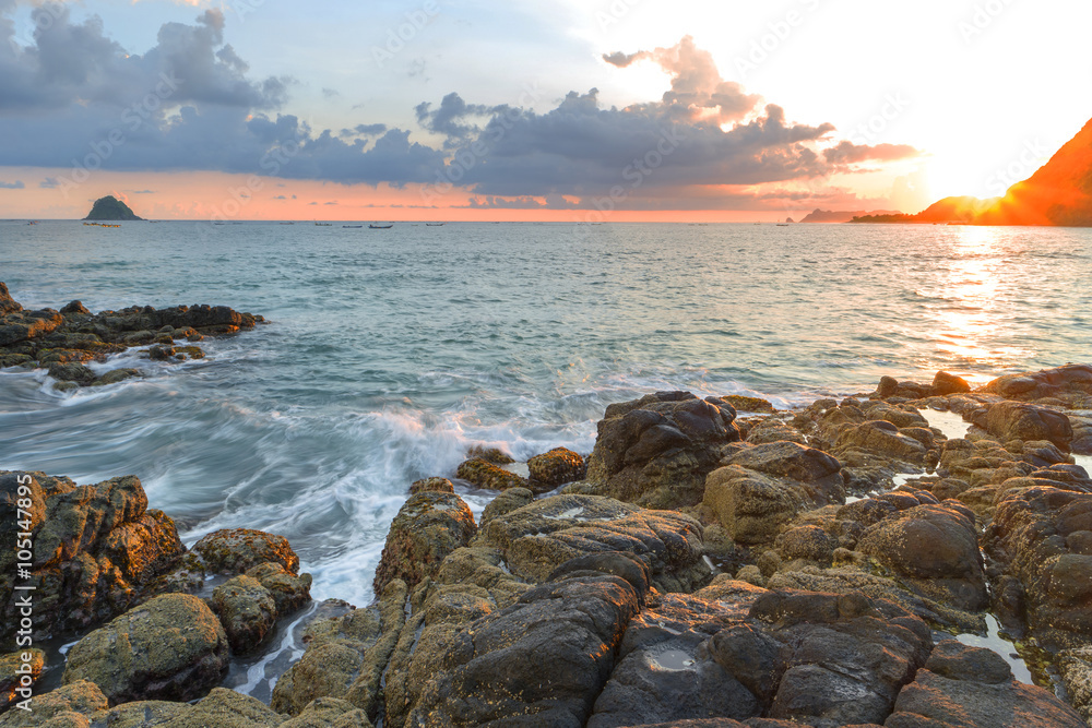 Natural rock with strong water wave and sunrise background at Belanak Beach, Lombok, Indonesia Natural rock with strong water wave and sunrise background at Belanak Beach, Lombok, Indonesia