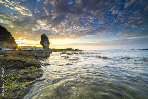 Rock green moss with sunrise background at Pantai Batu Payung ( Umbrella Rock Beach) lombok, Indonesia.