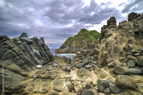 Natural rock with strong water wave and cloudy sunset background at Pantai Semeti Lombok, Indonesia. photo