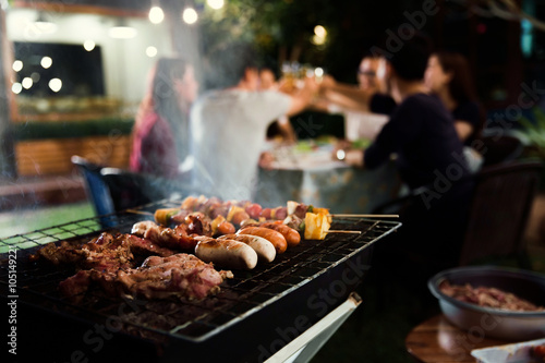 Photo Dinner party, barbecue and roast pork at night