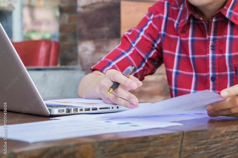 Business man holding a pen and analysis data from document Business man holding a pen and analysis data from document