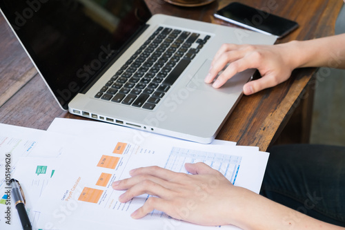 business man analysis data from paper sheet on wood table