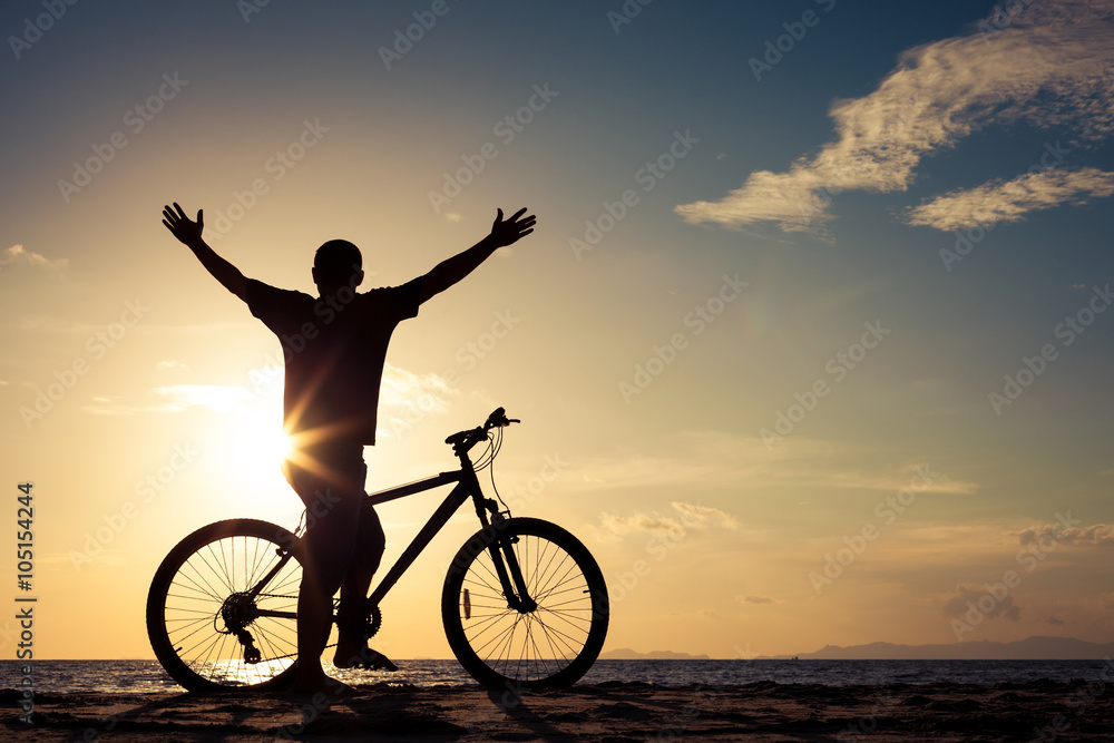 Obraz premium happy man with bicycle standing on the beach