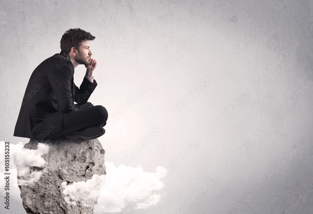 Office worker sitting on top of a rock Office worker sitting on top of a rock