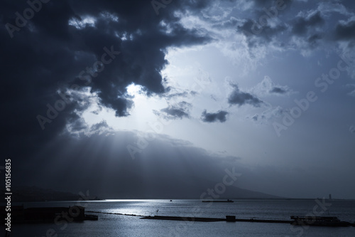 Sunlight goes through dark stormy clouds