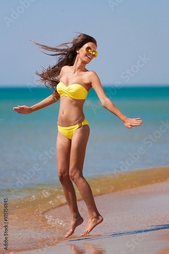 brunette woman yellow bikini jump sea