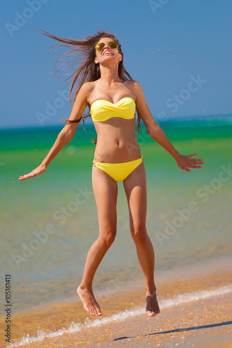 brunette woman yellow bikini jump sea