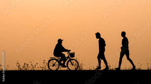 Silhouette of people cycling and walking relax