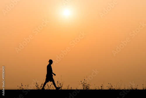 silhouette man walking on the sunset background