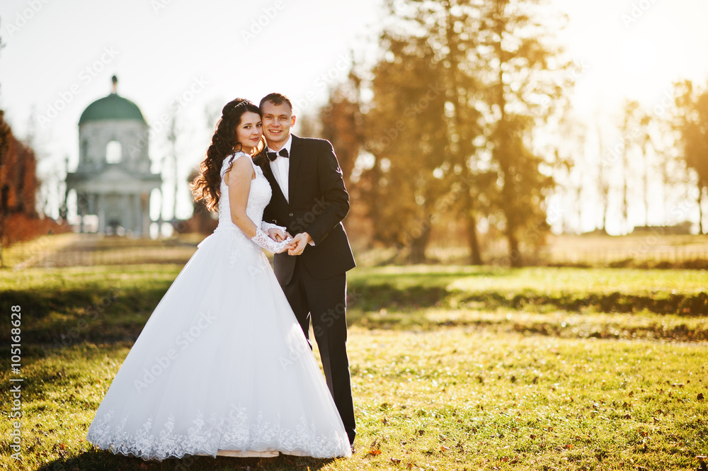 Fashionable wedding couple at sunny day background old church