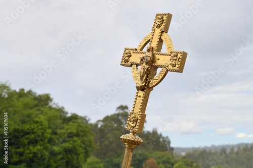 Catholic cross of gold against the sky