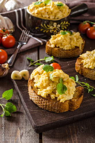Scrambled eggs with herbs and garlic on toasted bread