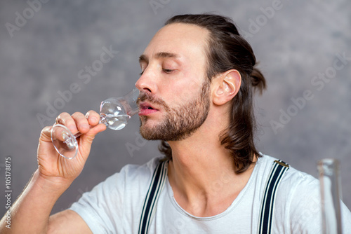 Photo young man drinking clear spirit