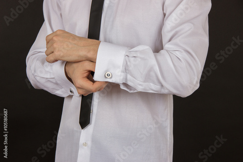 Sexy young man in a white shirt with a black tie and expensive c