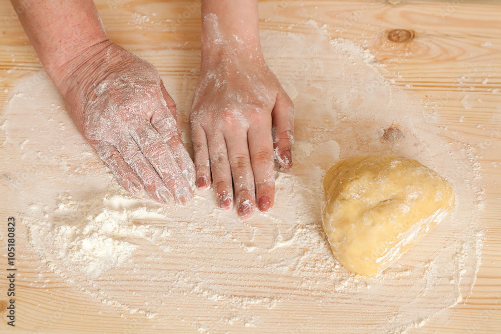 hands of the grandmother and hand of the granddaughter and dough hands of the grandmother and hand of the granddaughter and dough