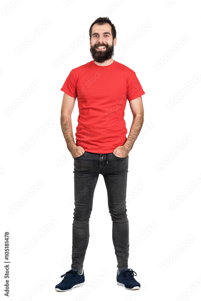 Happy positive friendly bearded man in red t-shirt and tight jeans laughing at camera. Full body length portrait isolated over white studio background. Happy positive friendly bearded man in red t-shirt and tight jeans laughing at camera. Full body length portrait isolated over white studio background.