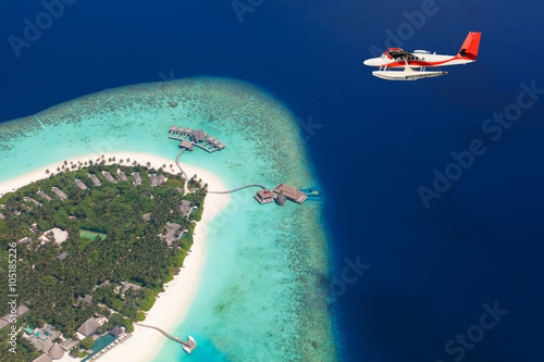 Sea plane flying above Maldives islands photo