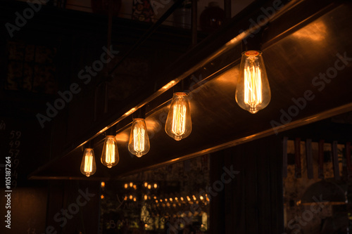 Decorative antique edison style light bulbs arranged in a row. Selective focus.