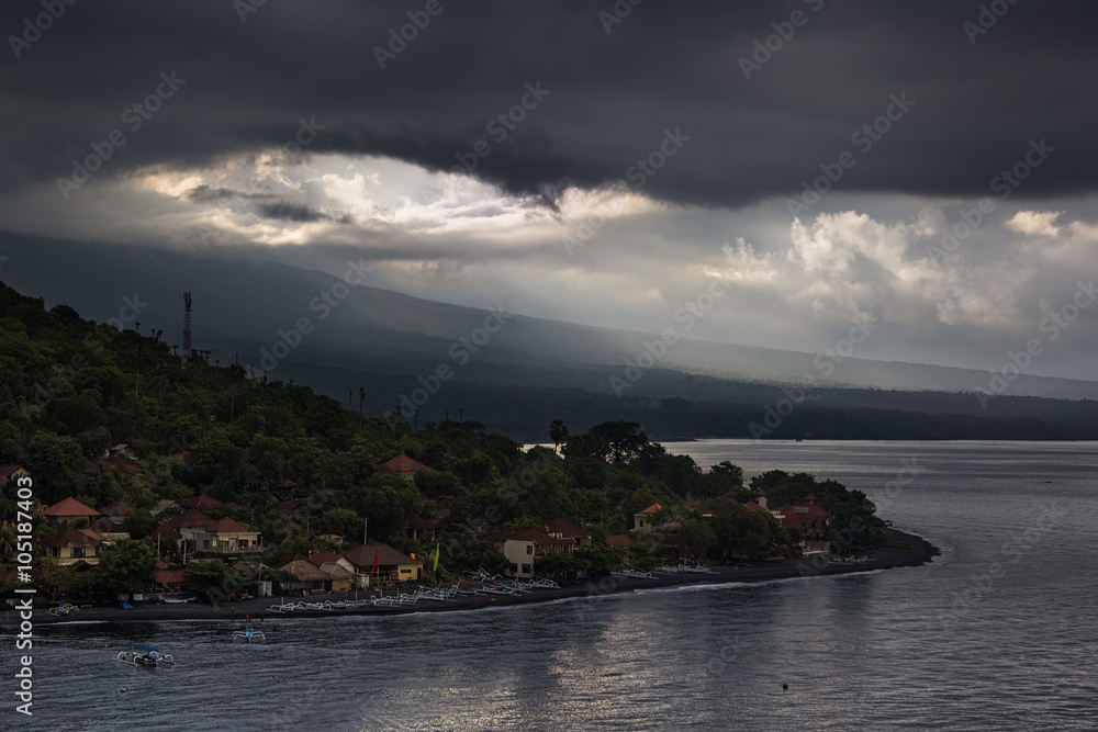 The dramatic sky over the Cape and the sea.  View of the overcast sky, the fishing village and the sea. Indonesia