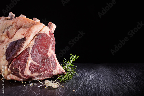 Raw beef ribs and seasoning over black background photo