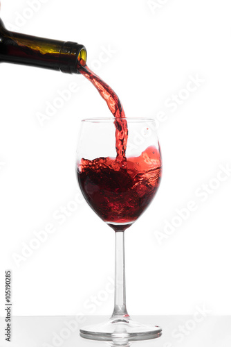 Red wine pouring from a bottle into a glass