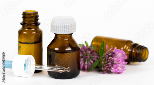 bottles with herbal oil on white