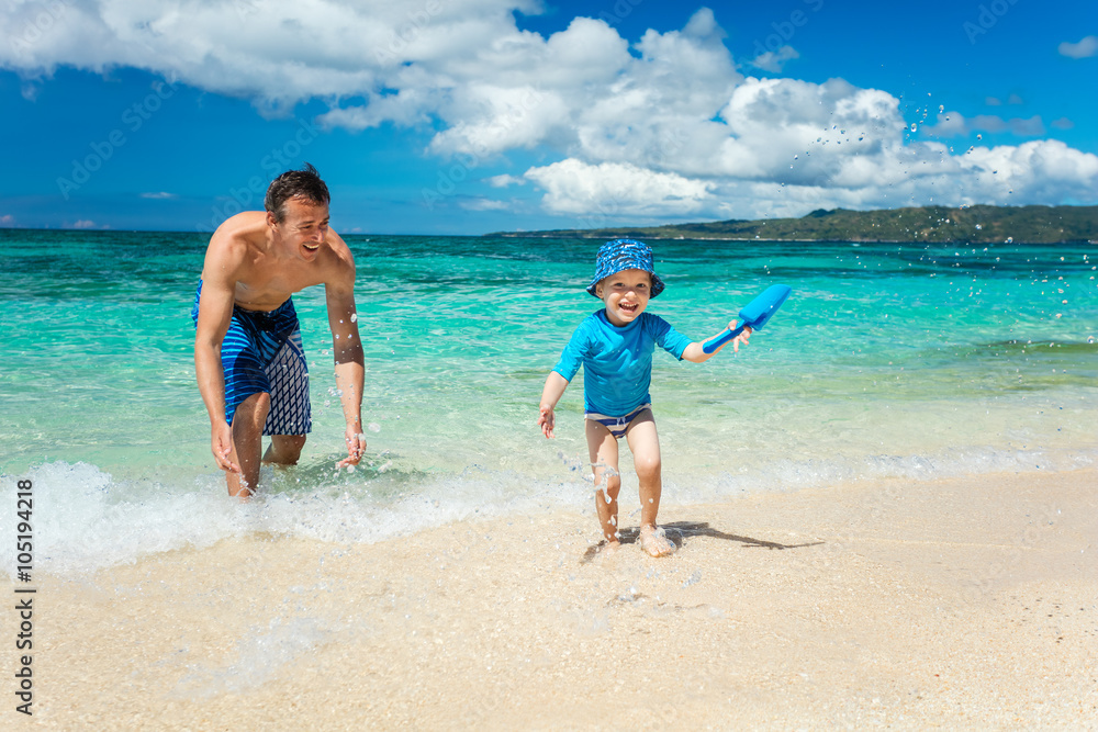 Father and son having fun on a tropical beach Father and son having fun on a tropical beach