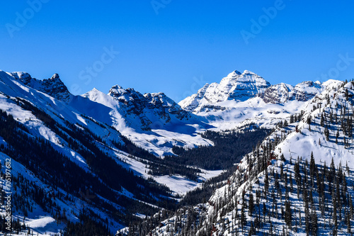 The Rocky Mountains of Colorado, with the Maroon Bells Peak, as viewed from the top of the Aspen/Snowmass ski resort on a clear winter day. photo