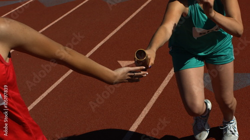 Running passing baton in relay photo