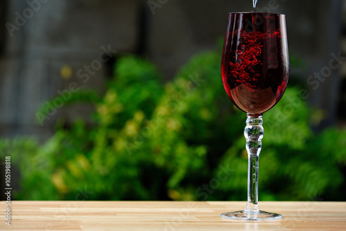 pouring drink on red glass