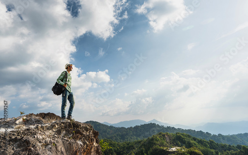 Guy with a travel backpack on the top of moumtain with beautiful valley background. Travel concept. photo