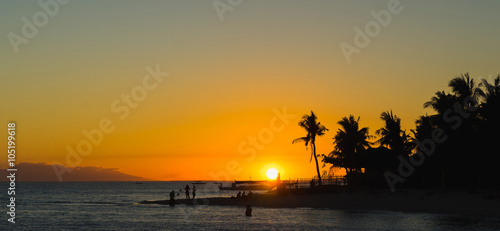 Beautiful colorful sunset over sea and boulders seen under the palms . wide banner edition. © upslim