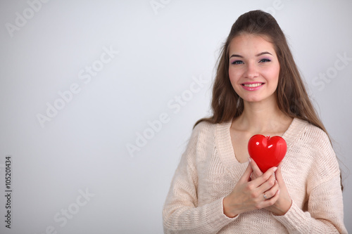 Portrait of beautiful happy woman holding a symbol heart. 