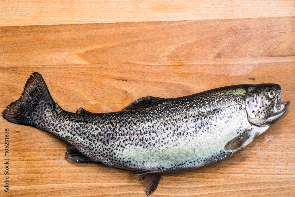 Raw trout or freshwater fish on a wooden board. Raw trout or freshwater fish on a wooden board.